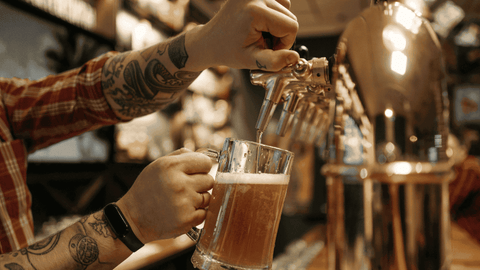 personne servant de la biere au comptoir d'un bar